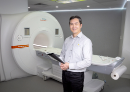 Apex Radiology MRI Technician smiling and standing towards the camera with an MRI machine in the background